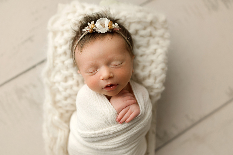 Newborn baby girl in cream wrap