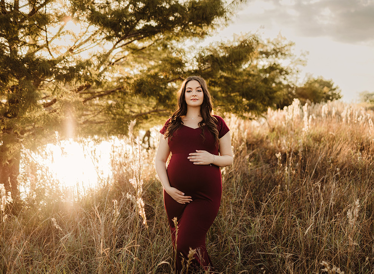 Pregnant woman in field in maroon dress
