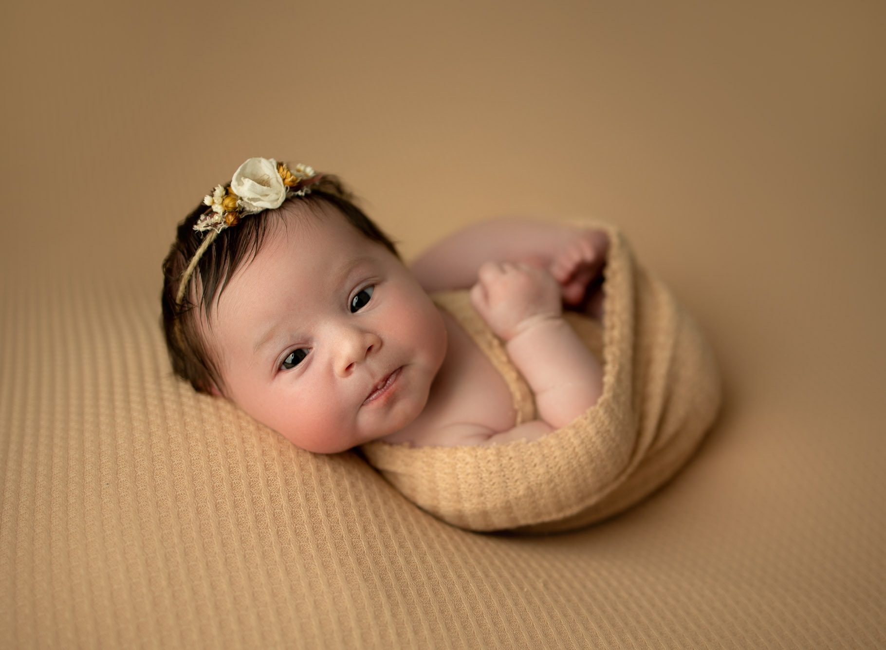 Newborn baby girl on beige blanket