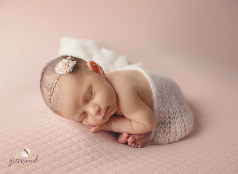 Newborn baby girl portrait pink backdrop womb 
