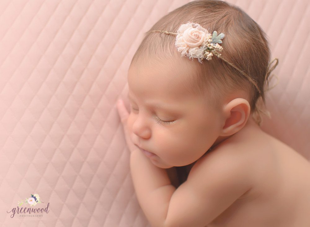 Newborn baby girl portrait side lying 