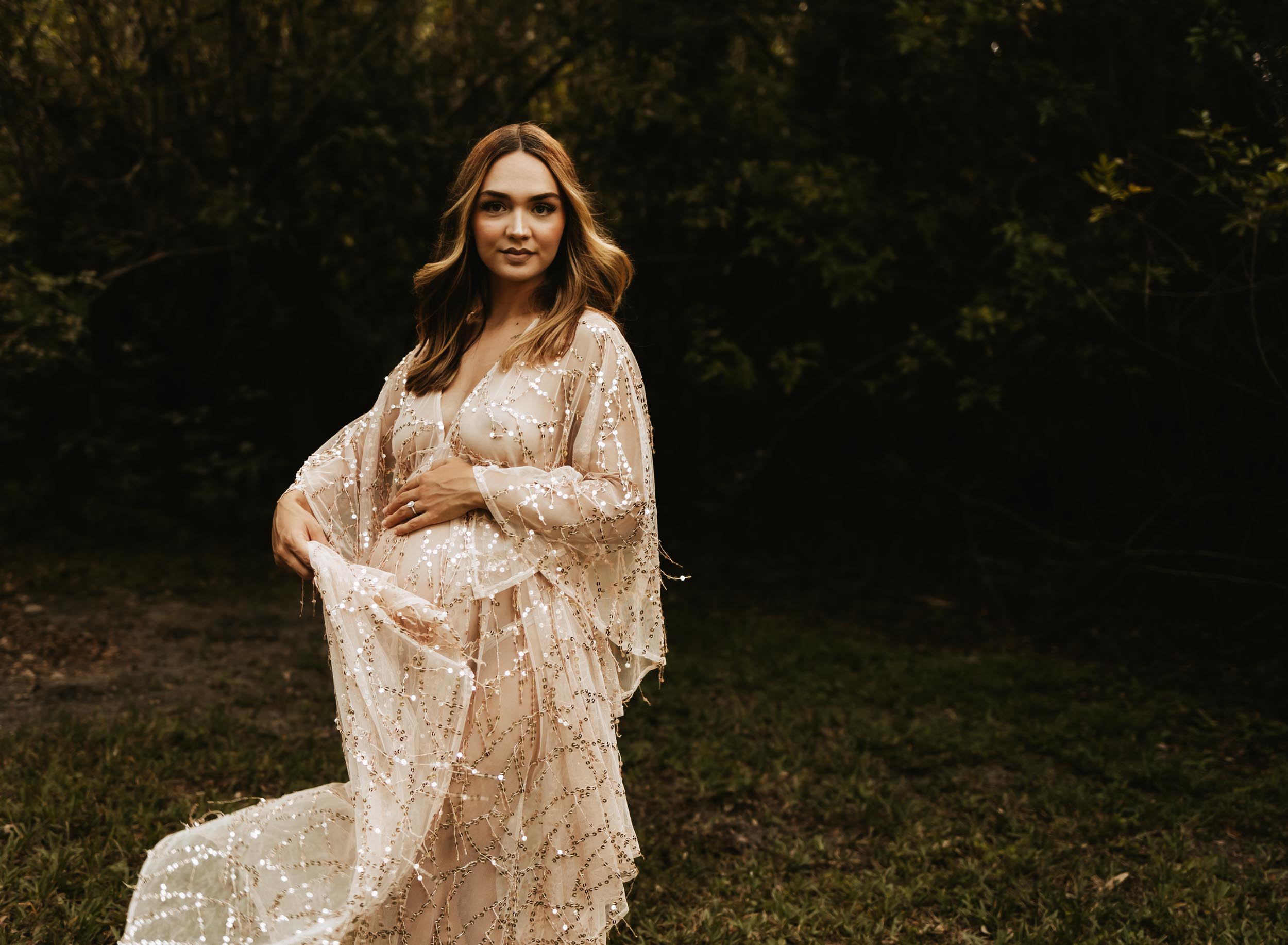 maternity portrait of mom wearing pink flowy dress and swinging the dress around