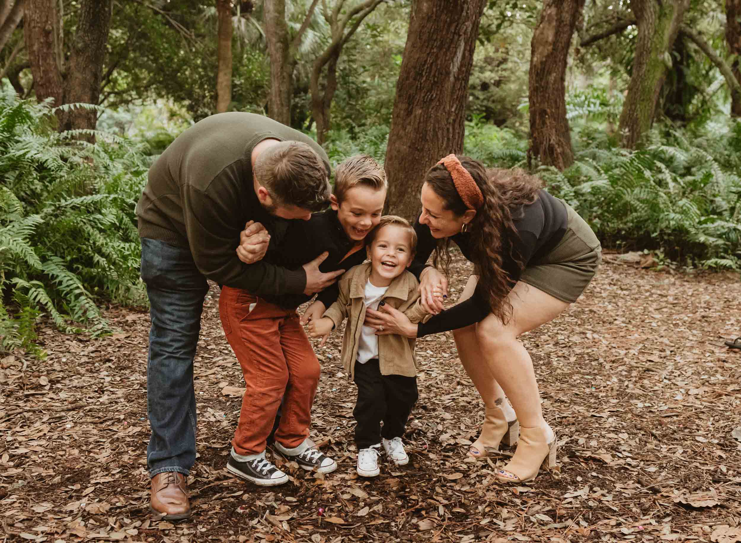 family of four ticking and having fun outdoors as a family photographer West Palm Beach takes their photo.