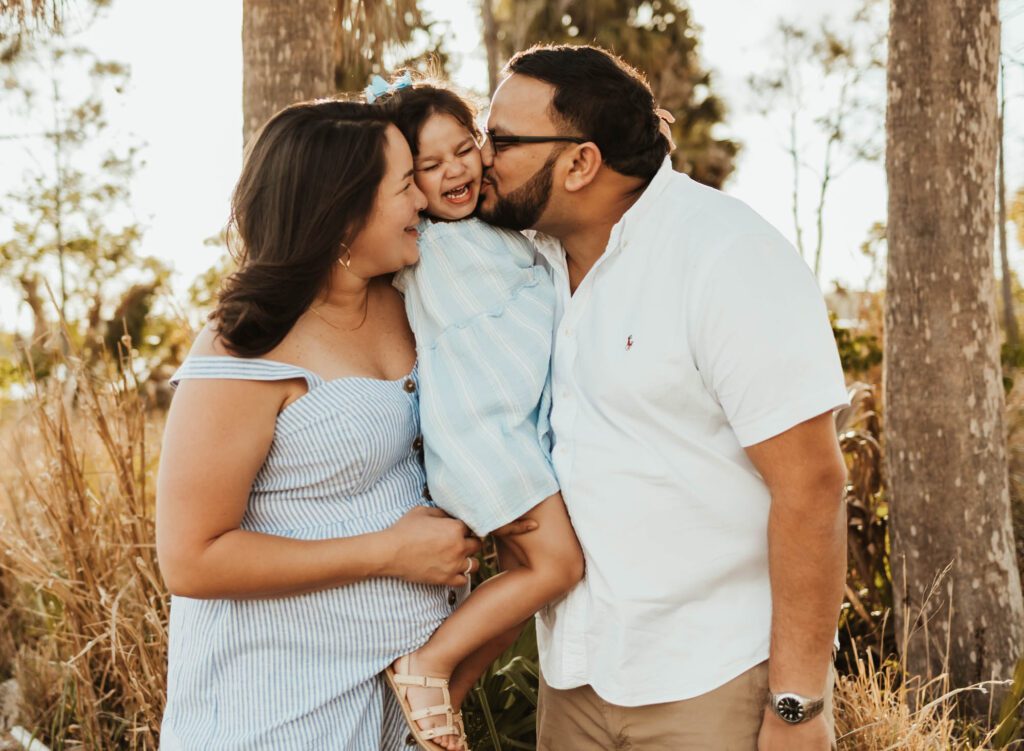 Mom, dad and toddler daughter hugging and laughing in photos