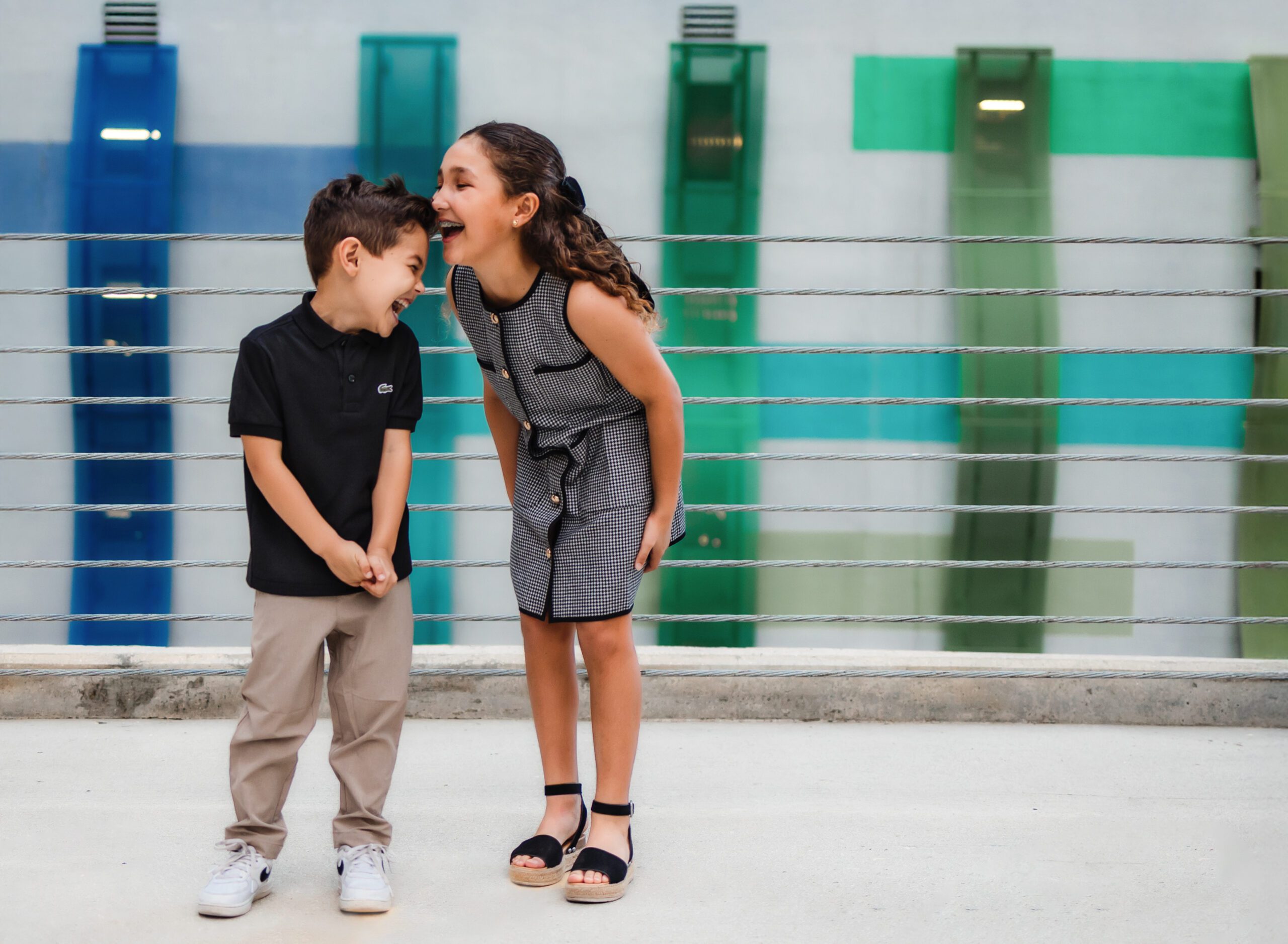 Siblings laughing together on rooftop garage, Fort Lauderdale, FL
