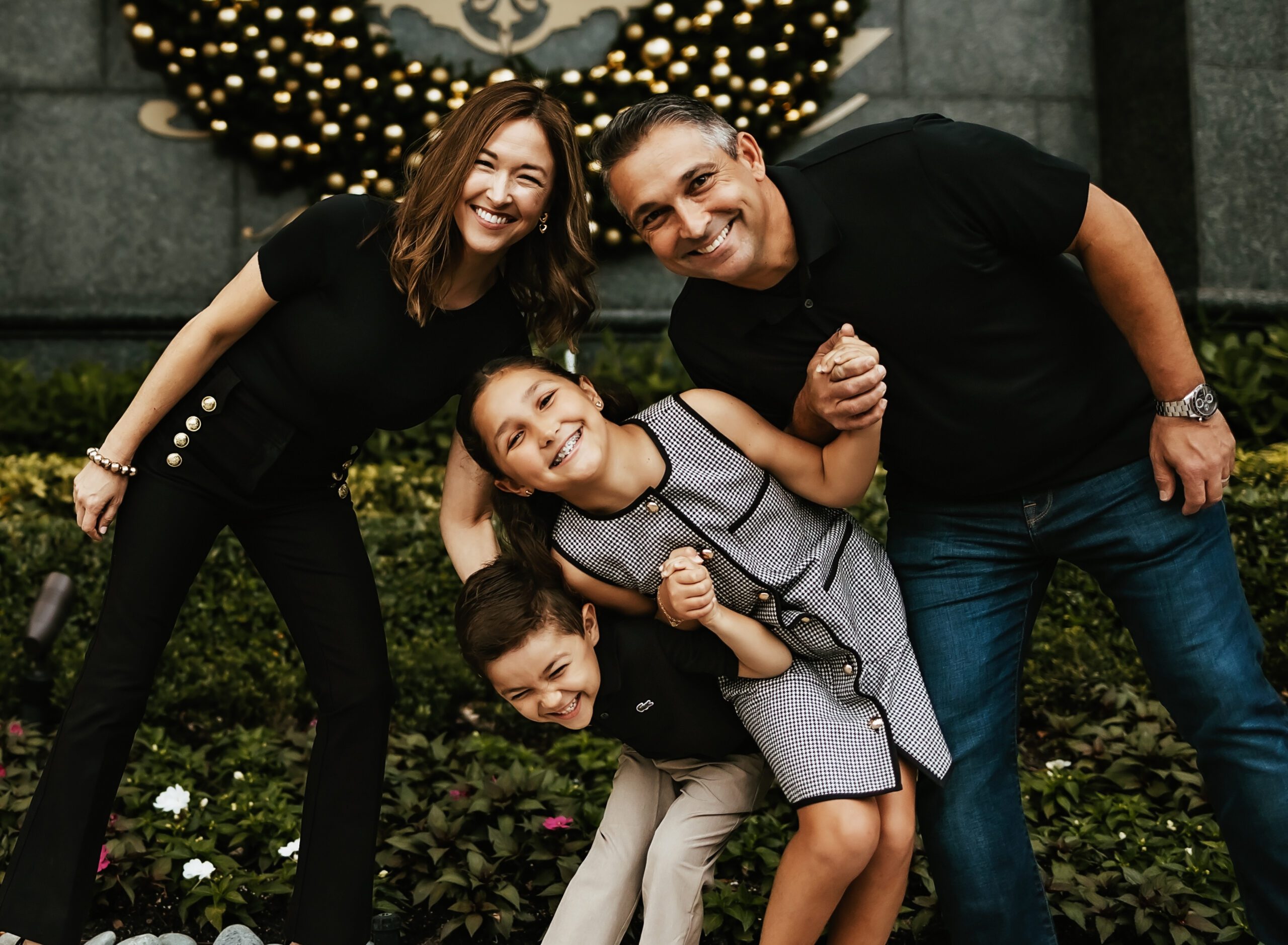 Family of four laughing in front of holiday wreath, Riverside Hotel, Fort Lauderdale