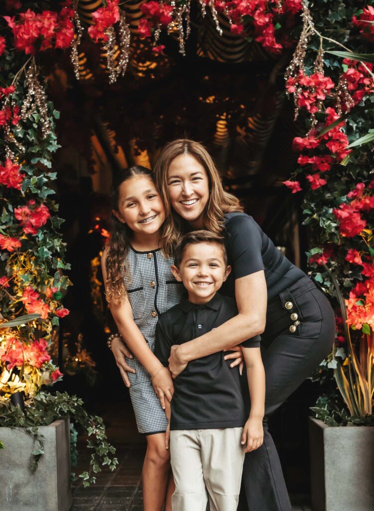 mom and kids posing for professional photoshoot in Fort Lauderdale under floral arch