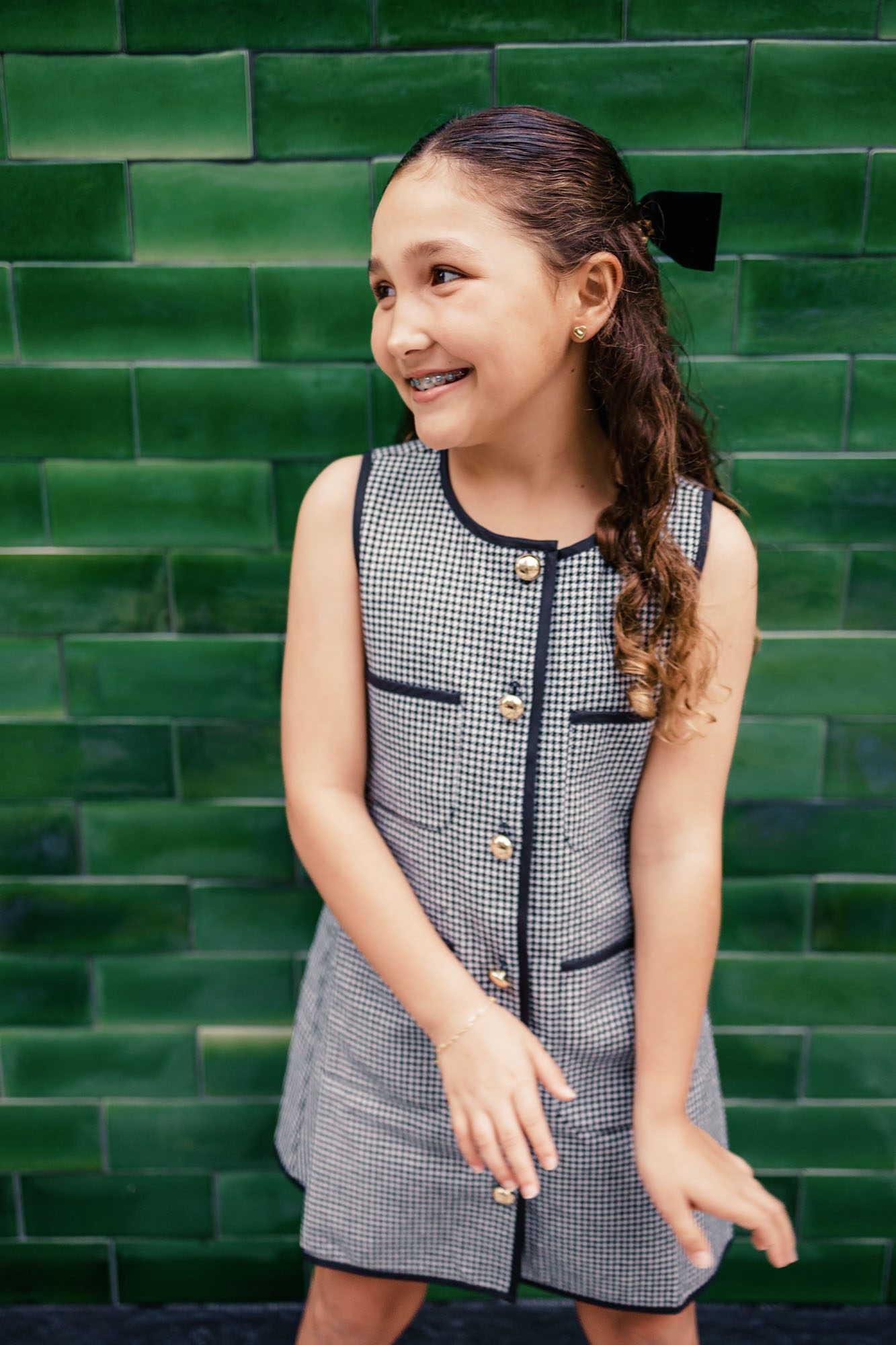 Las Olas green tile wall with tween girl smiling while leaning on it.