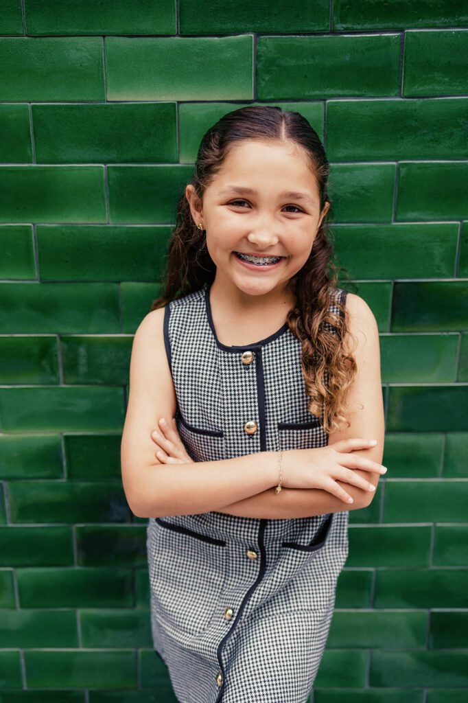 Tween girl by green tile wall on Las Olas, Family Photographer Fort Lauderdale