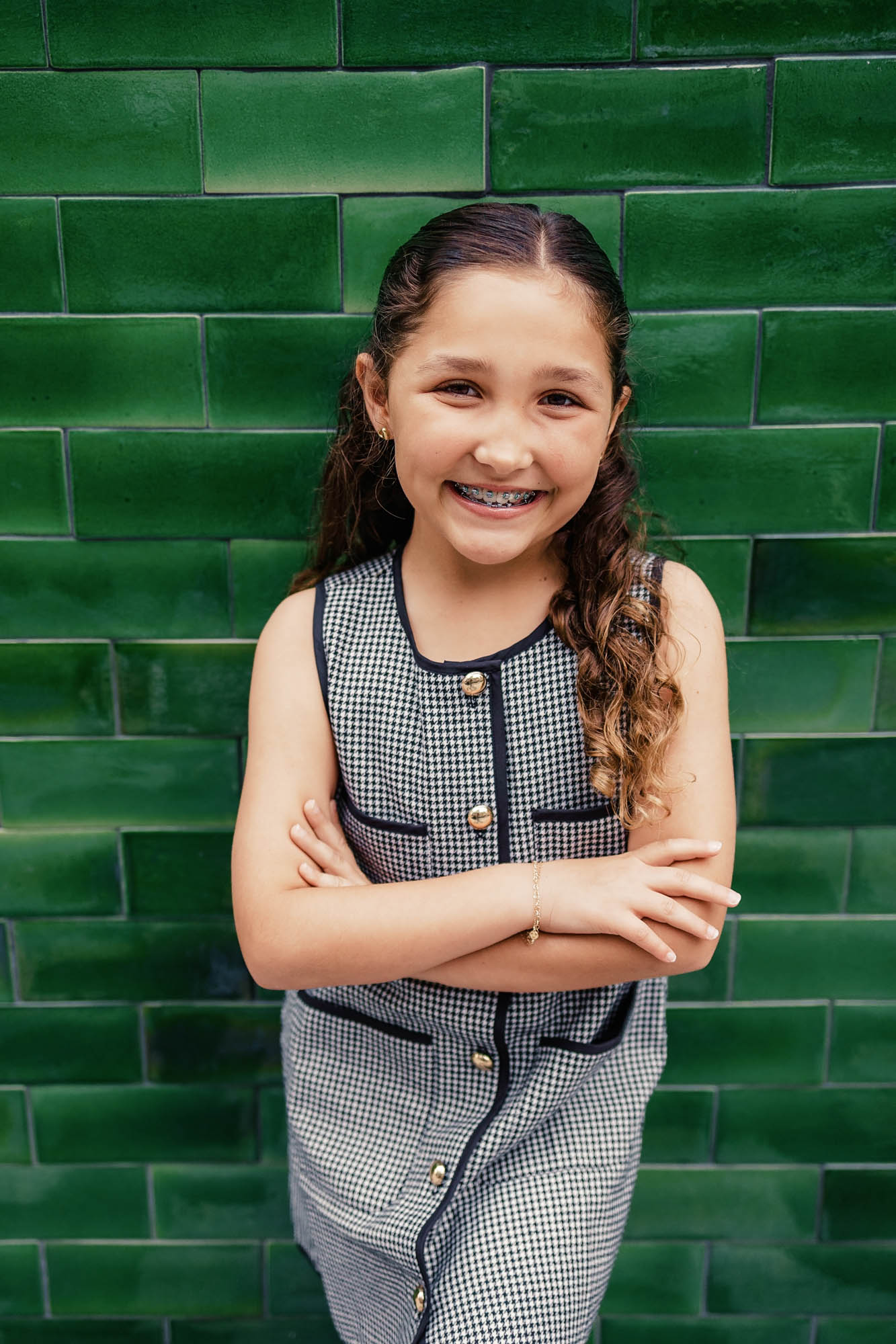 Tween girl posing in front of bright green tile wall during her Fort Lauderdale family photoshoot
