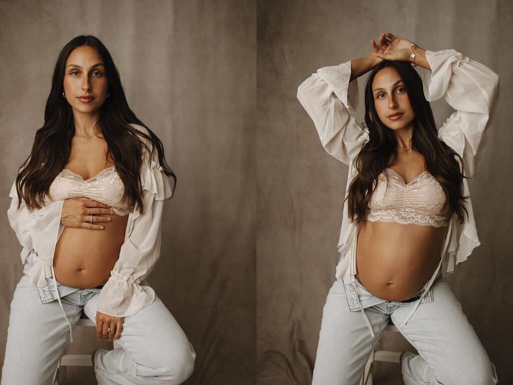 boho chic maternity studio photoshoot, mom sitting on stool in jeans and flowy top with baby bump exposed