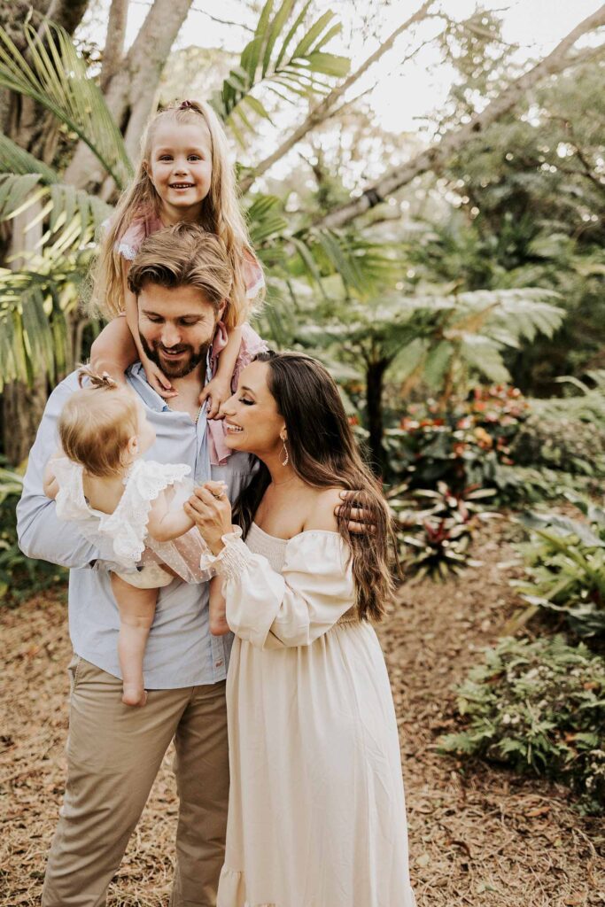 Dad holding both his daughters while mom cuddles in for a photo