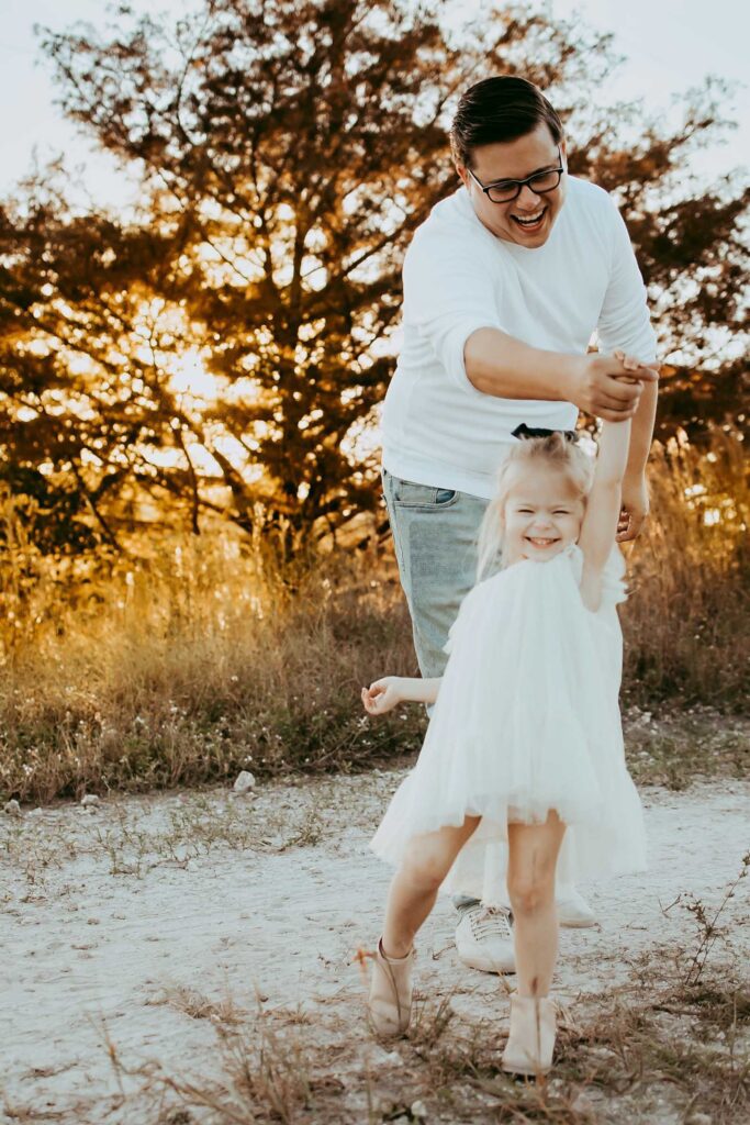 Dad twirling his little girl at golden hour