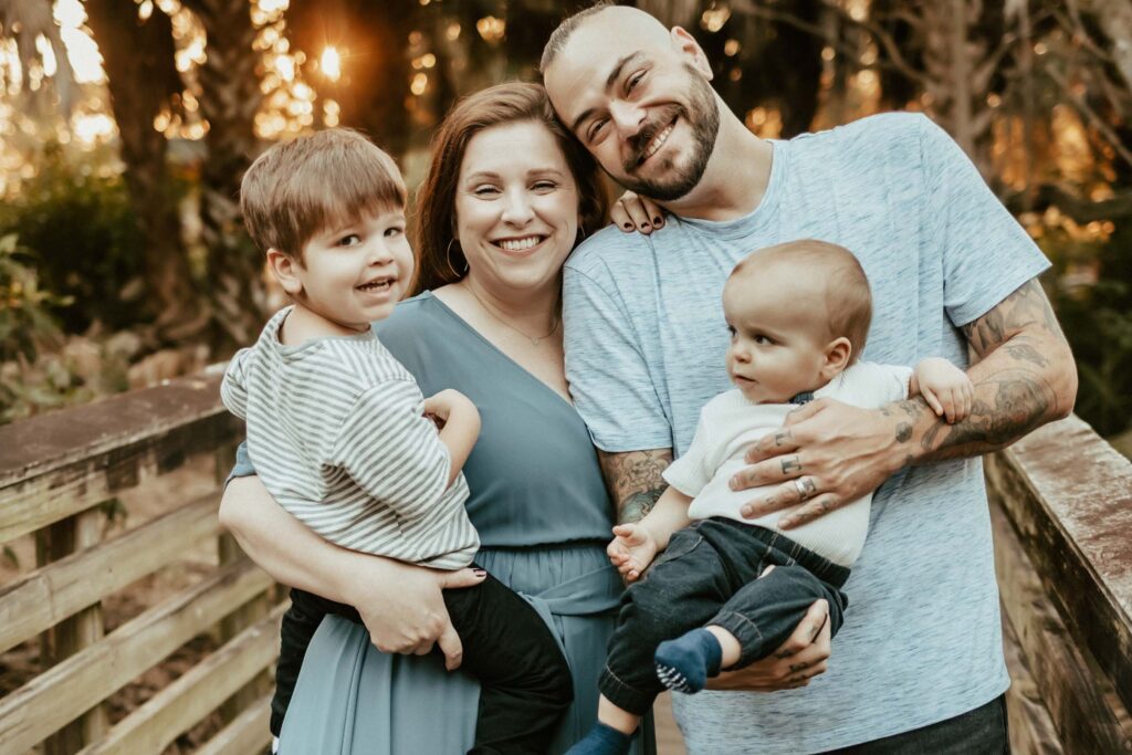 Parents each holding their baby boys smiling at the camera