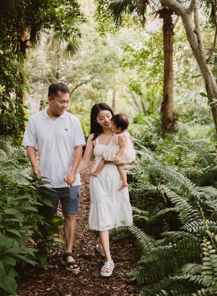 Family with shy baby walking in park for photoshoot