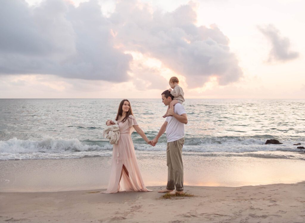 Family walking follow the leader style along the beach in Boca Raton at a sunset family photoshoot