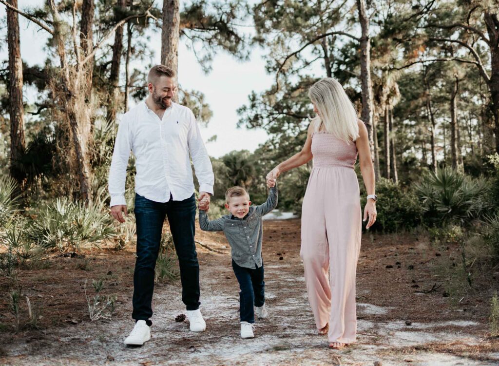 Family of three outdoor family photoshoot poses. Walking together is a good family photo idea.