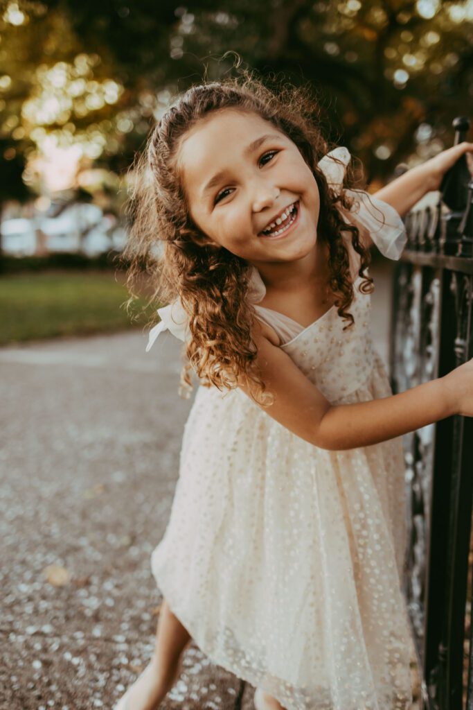 Little girl smiling big in a sparkly dress at her family photoshoot in Fort Lauderdale